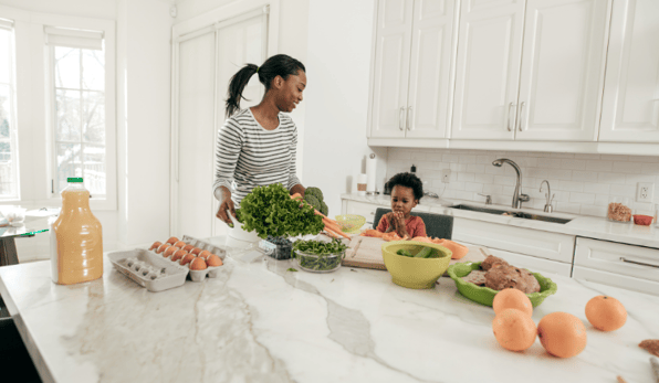 mom and young son cooking healthy meal in kitchen