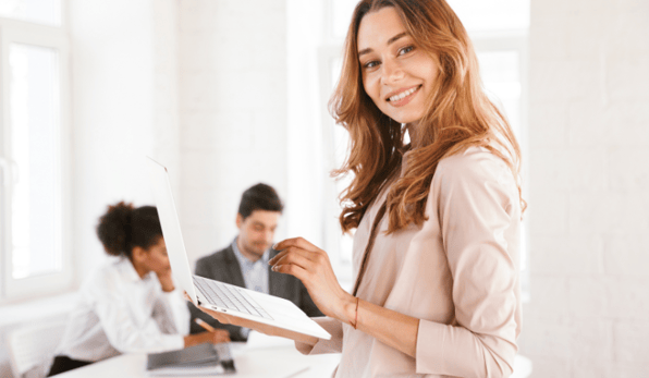 woman standing and holding a laptop